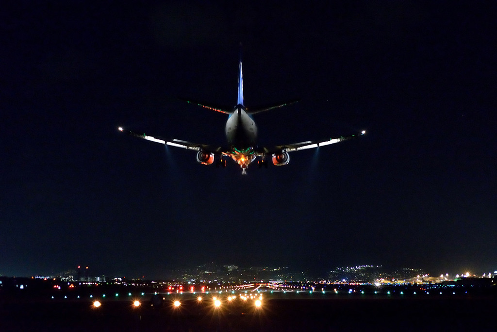夜の空港に着陸する旅客機